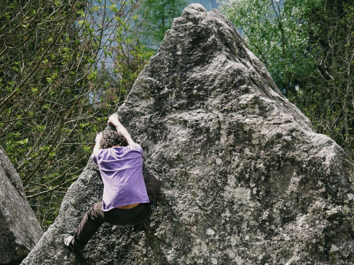 Grimpeur sur un bloc de rocher en pleine nature