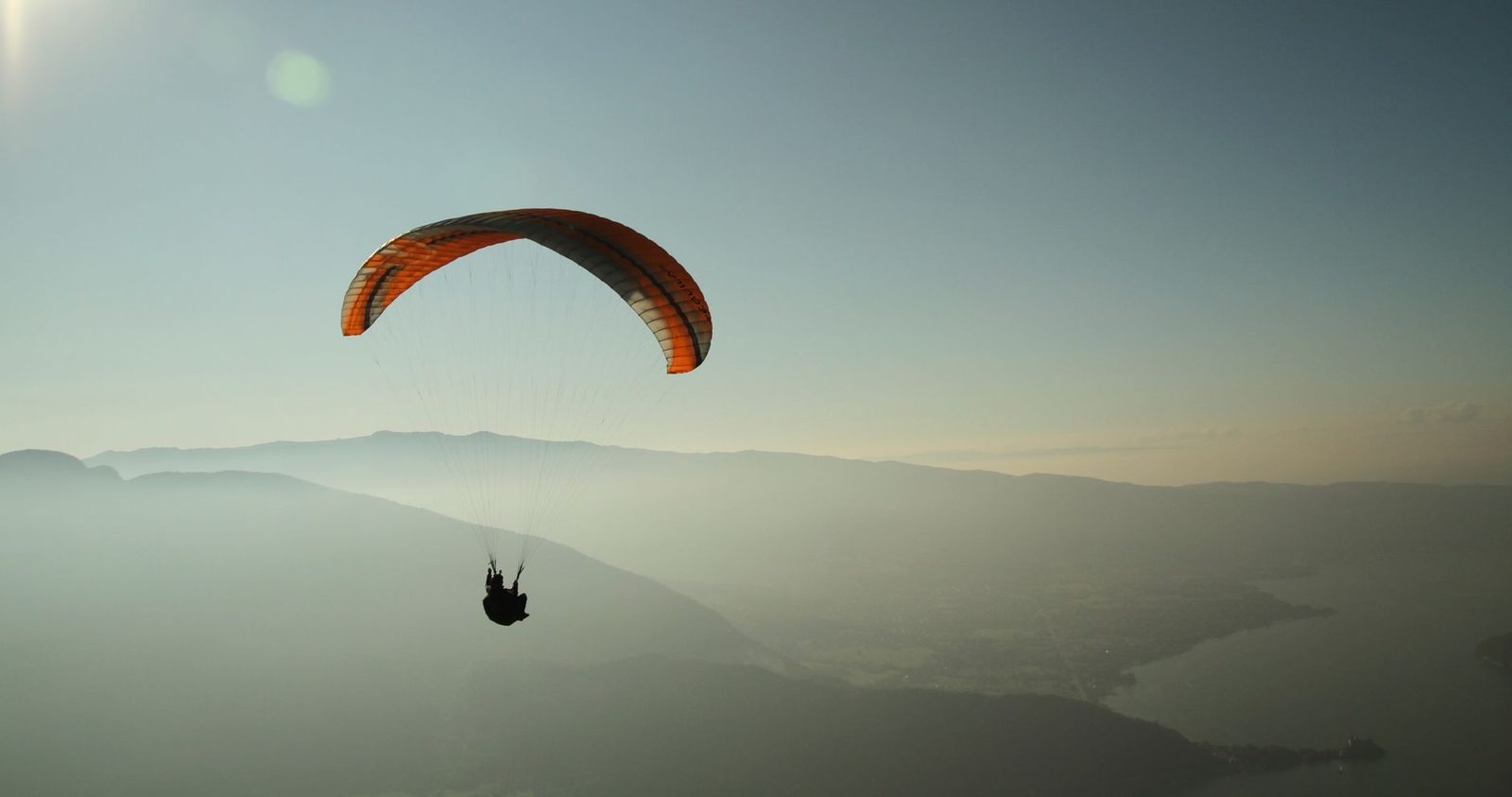 Parapente vu de loin au-dessus d un paysage vallonne