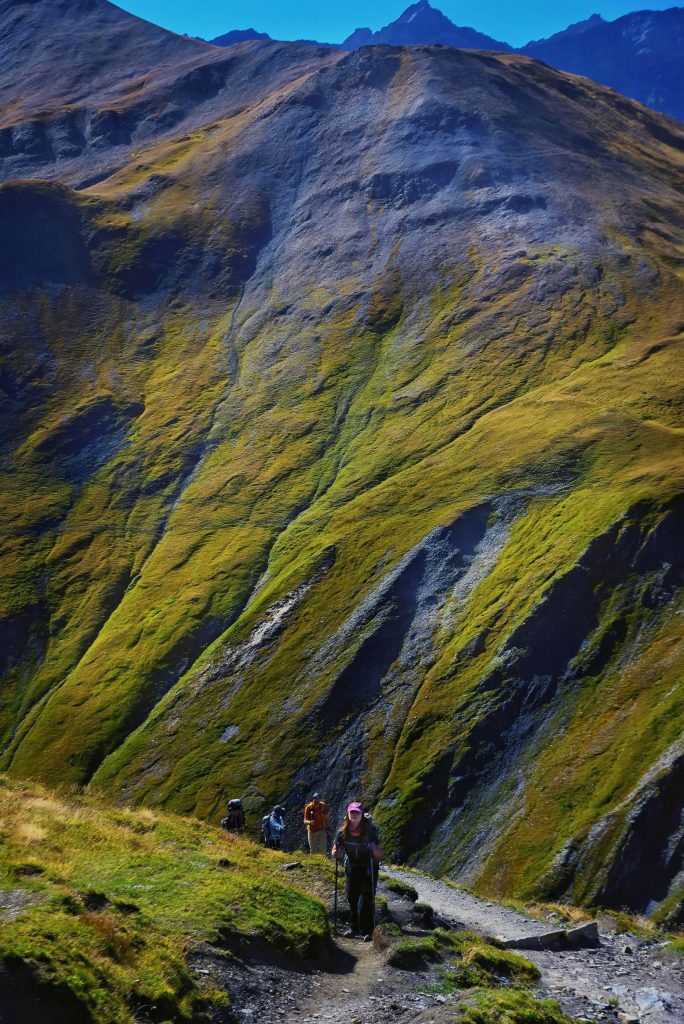 Groupe de randonneurs sac au dos sur un sentier de montagne en lumière d'automne, panorama des activités outdoor en France