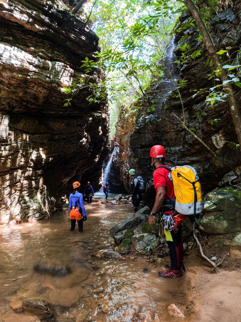 Groupe de canyonistes casqués progressant dans un canyon étroit encaissé avec petite cascade, canyoning dans les gorges du Verdon
