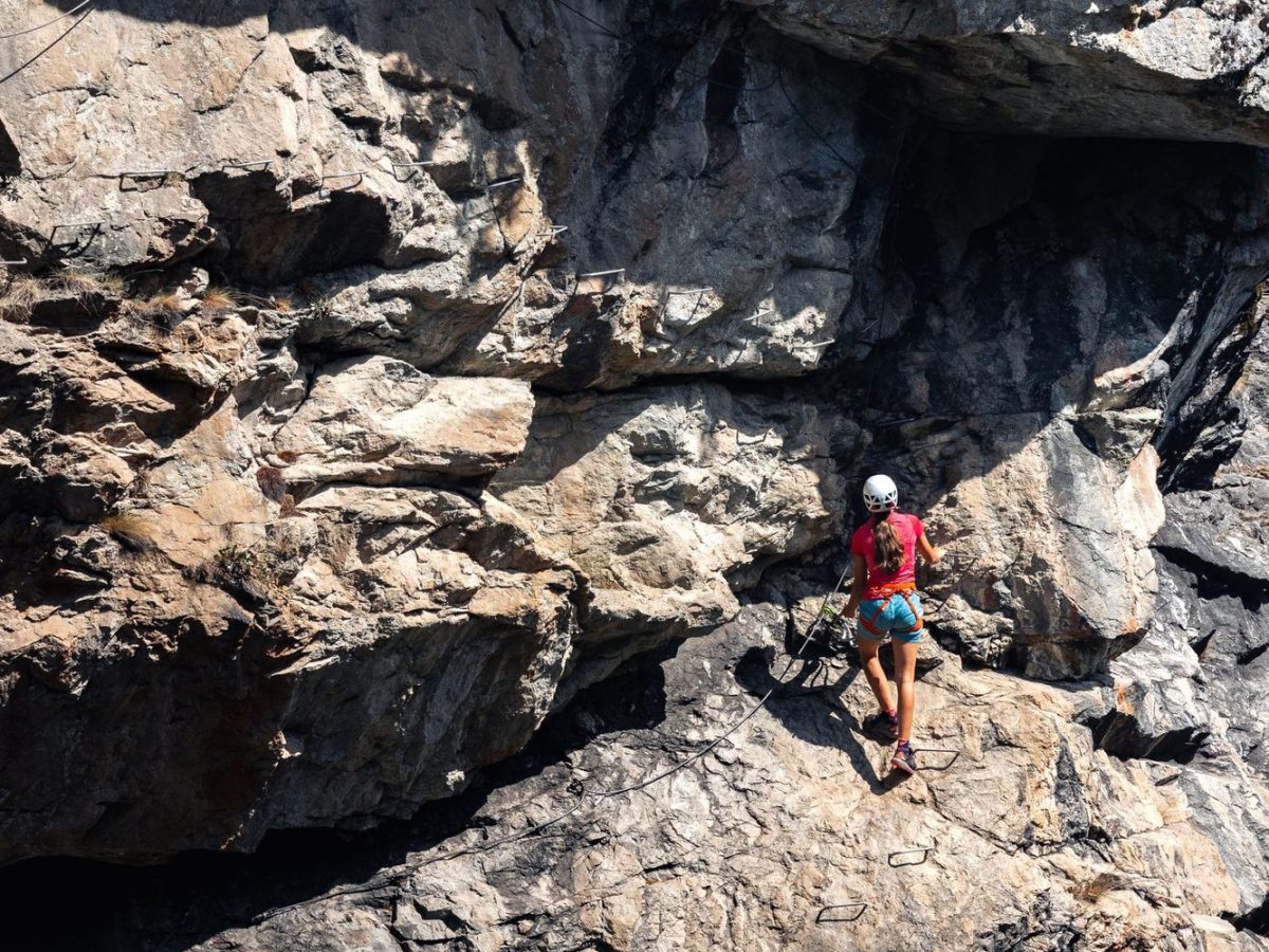 Grimpeur sur un parcours de via ferrata, cable en paroi rocheuse