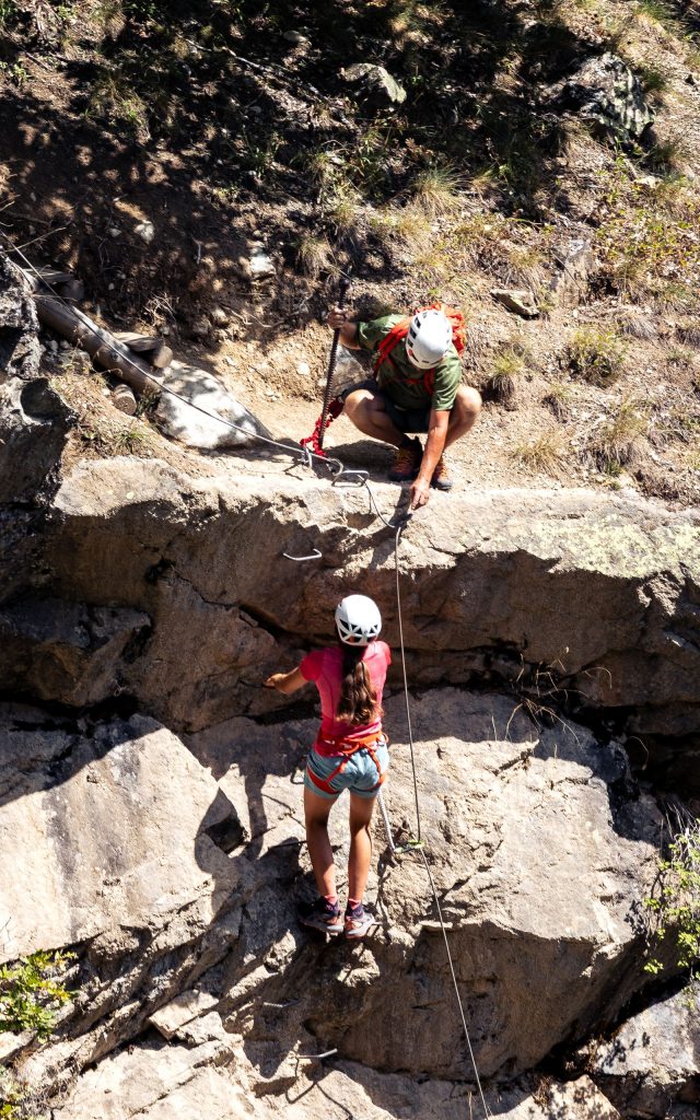 Deux pratiquants casqués et encordés progressant sur une paroi rocheuse équipée, illustration des meilleures via ferrata de France