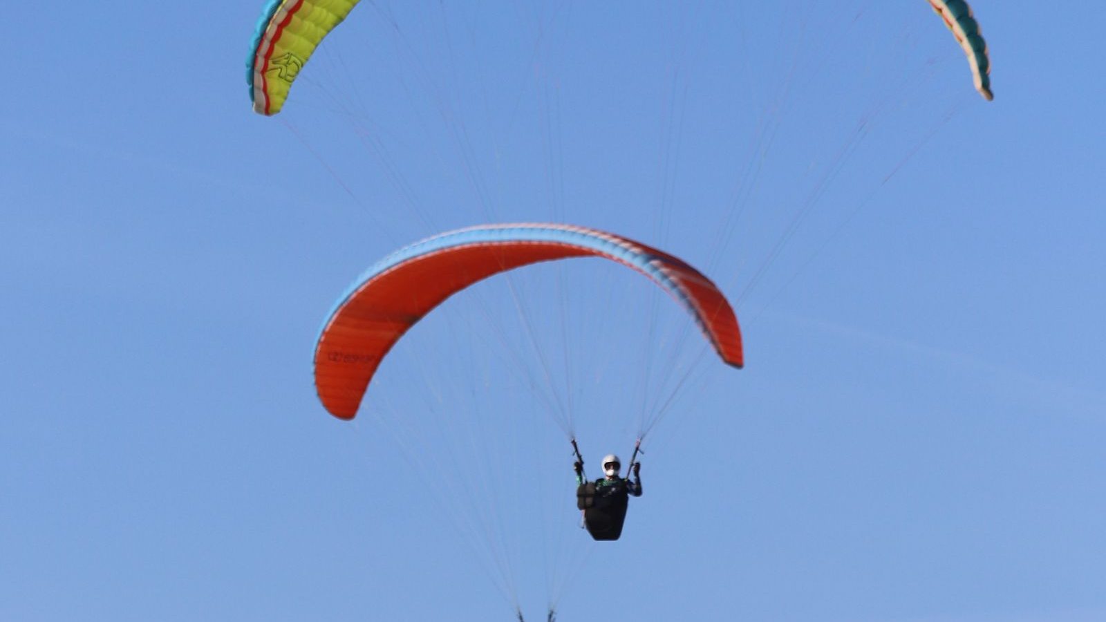 Vol biplace en parapente sous un ciel bleu dégagé au-dessus des montagnes, activité parapente près de Chamonix