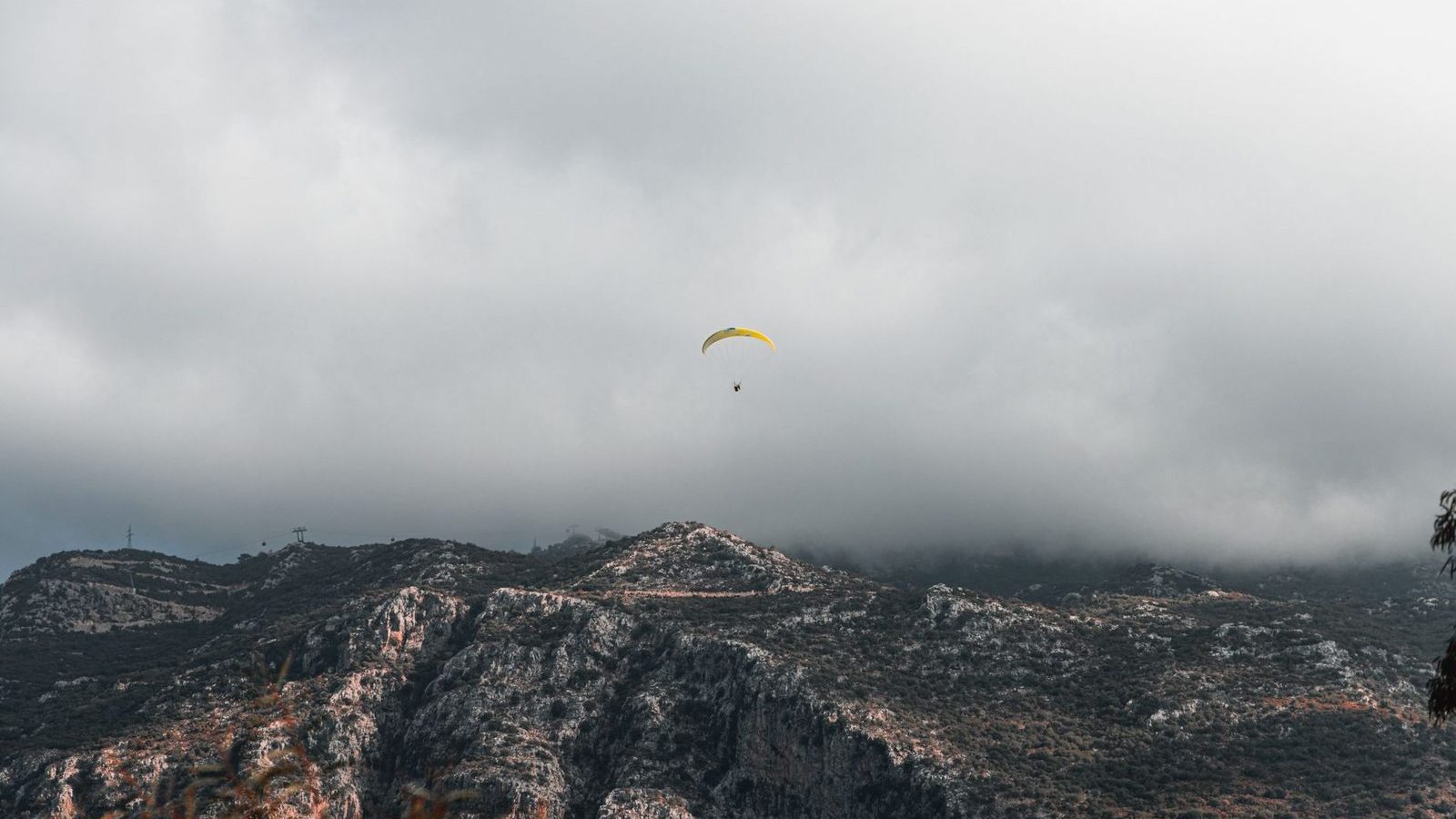 Voile de parapente au-dessus d un massif montagneux brumeux