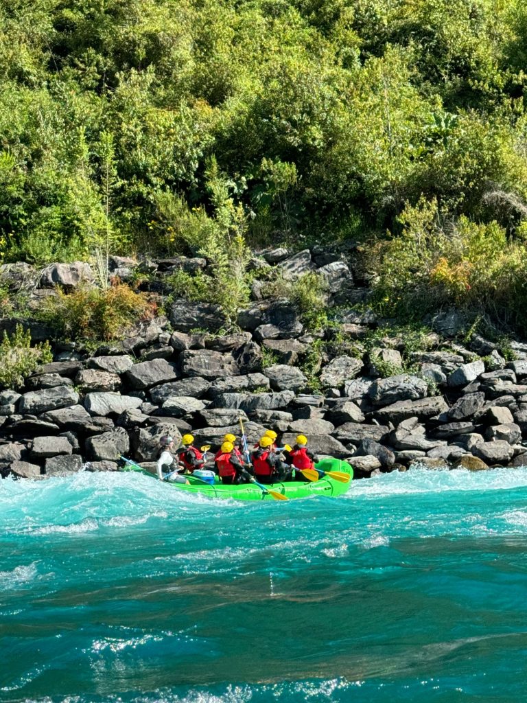 Équipage casqué pagayant dans un raft au fil des rapides d'une rivière de montagne, rafting dans les Pyrénées