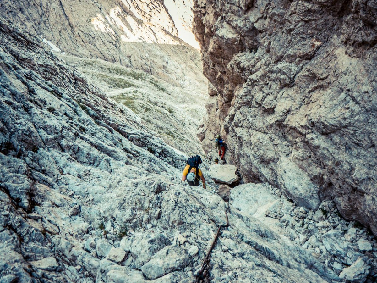Deux pratiquants encordés progressant sur une arête rocheuse de haute montagne, via ferrata dans les Alpes
