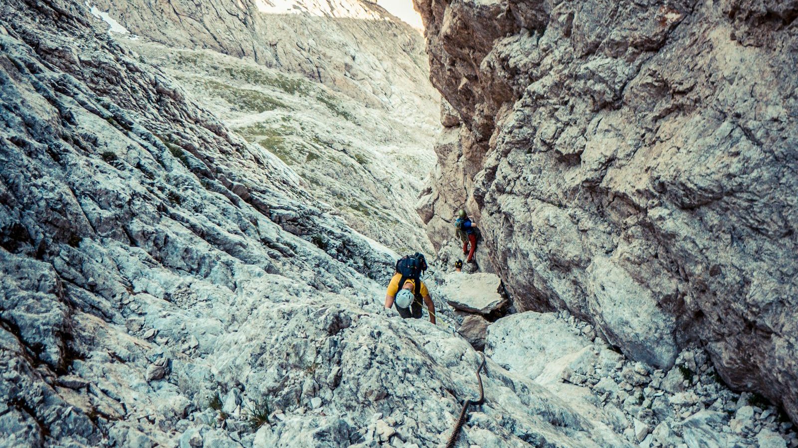 Deux pratiquants encordés progressant sur une arête rocheuse de haute montagne, via ferrata dans les Alpes
