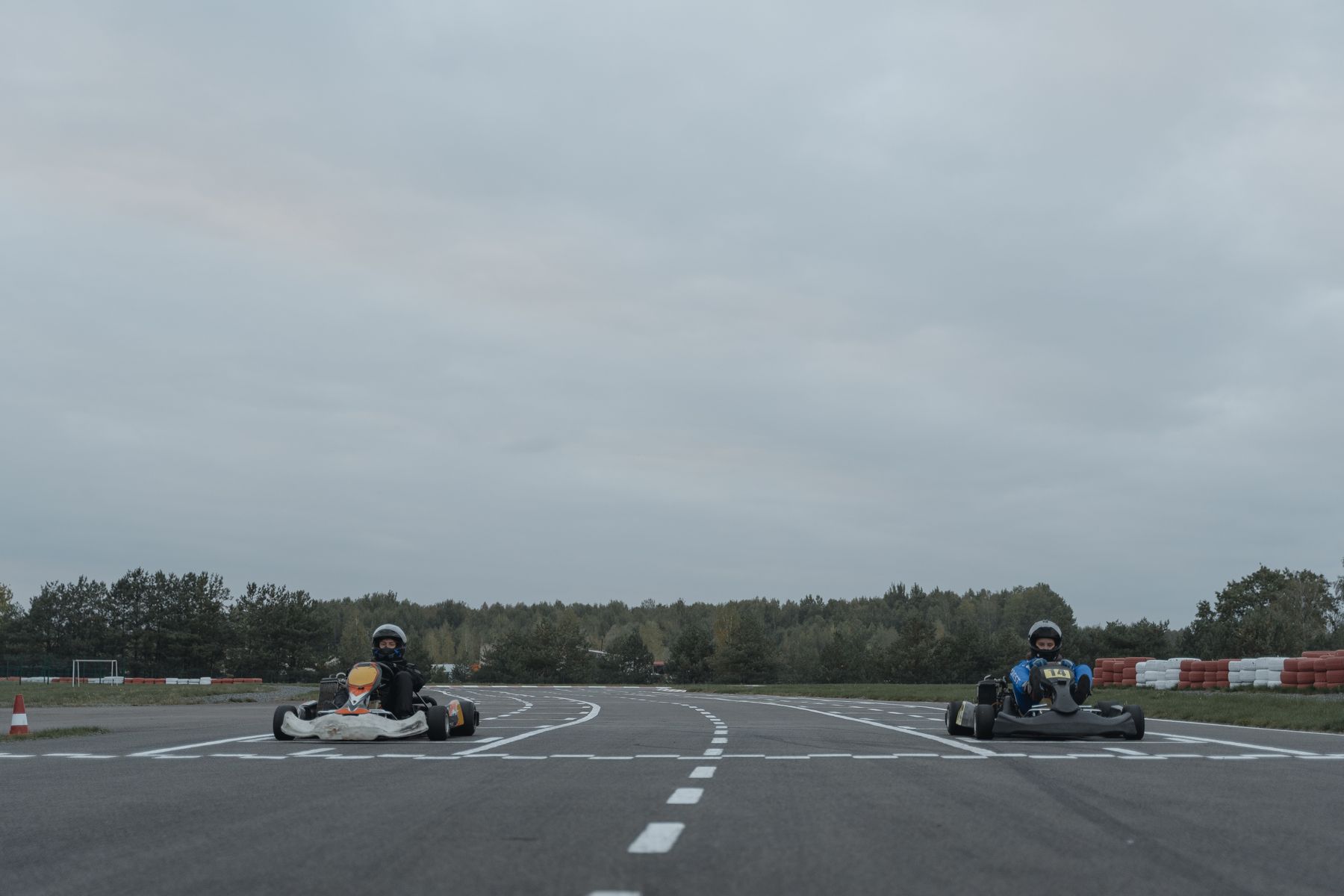 deux pilotes au volant de karts de compétition sur un circuit outdoor