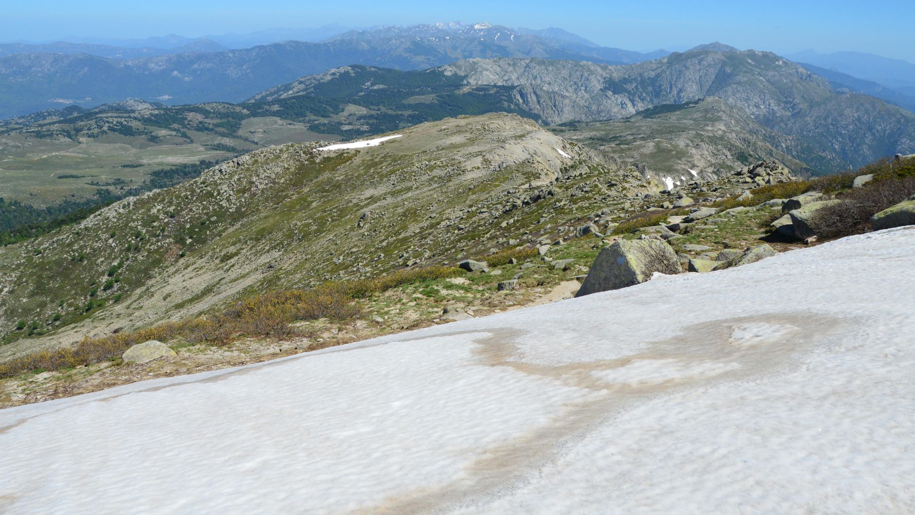 paysage de haute montagne corse avec relief accidenté et sentier de randonnée serpentant entre les rochers
