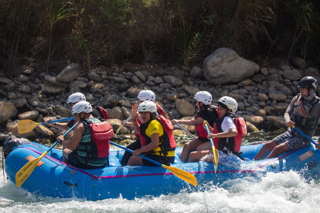 Équipe en raft casquée franchissant des vagues d'eau vive sur une rivière encaissée, rafting sur l'Ubaye