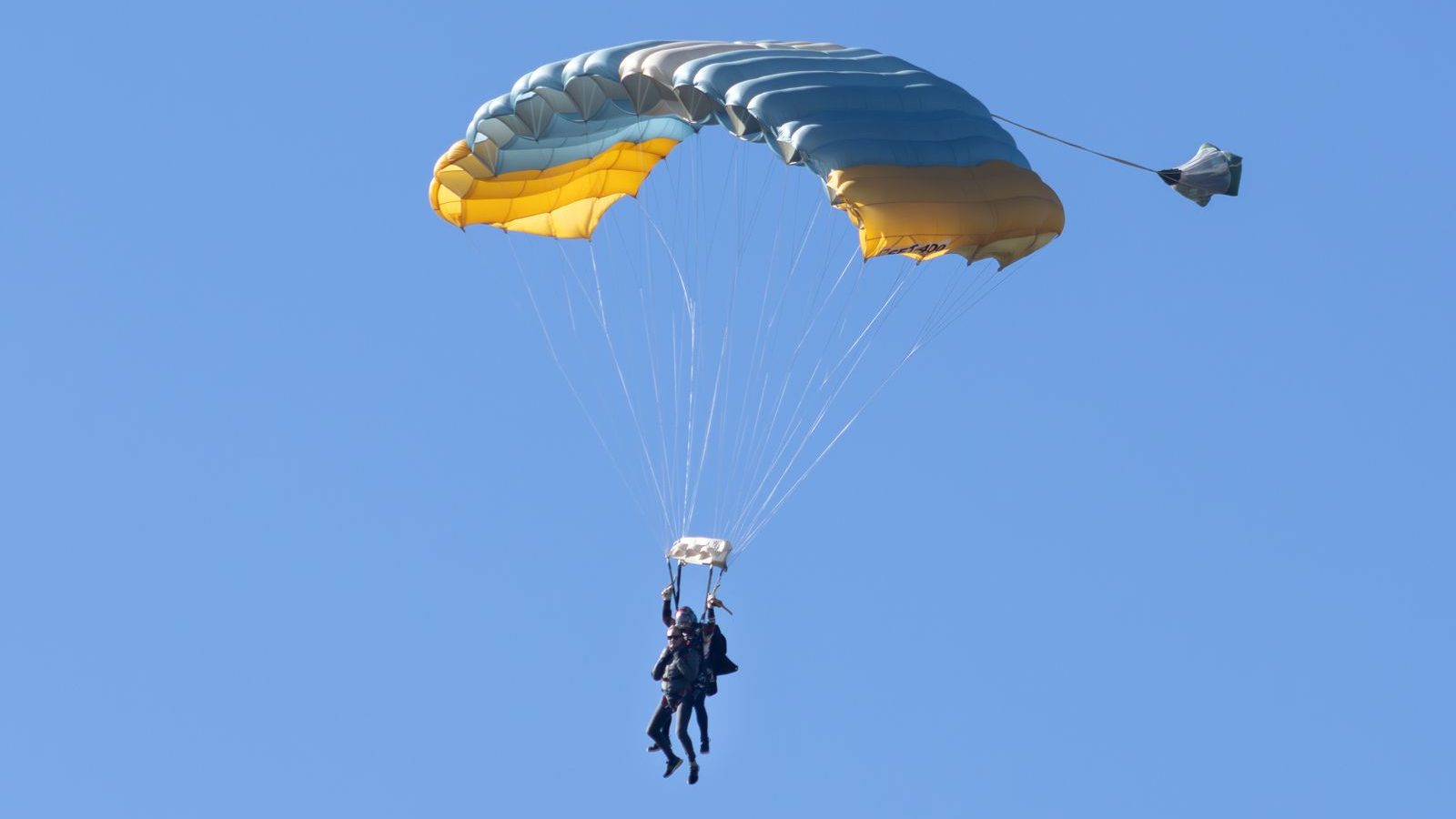 Parachute tandem ouvert en plein vol dans un ciel bleu clair et froid, saut en parachute près de Montpellier
