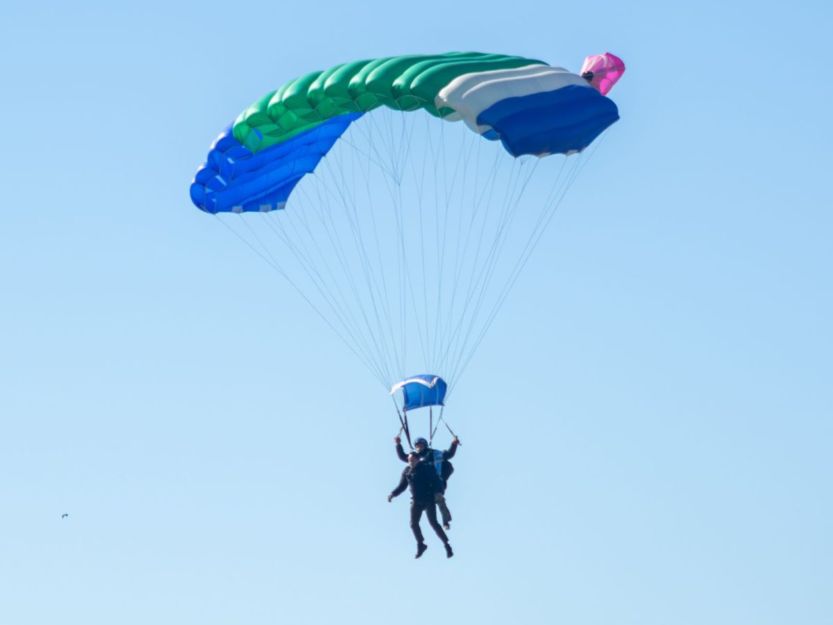 Parachute tandem ouvert descendant sous un ciel bleu dégagé, illustration d'un saut en parachute près de Nice