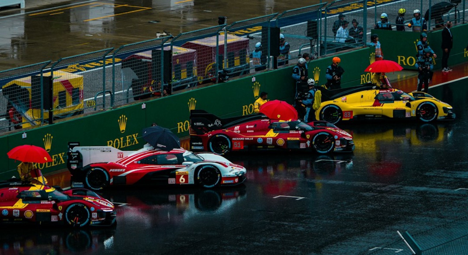 Pilote casqué sous la pluie dans les stands d'un circuit automobile