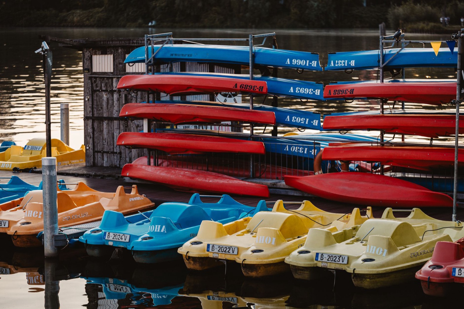 Kayaks alignés devant le comptoir de location d'une base nautique au bord d'une rivière